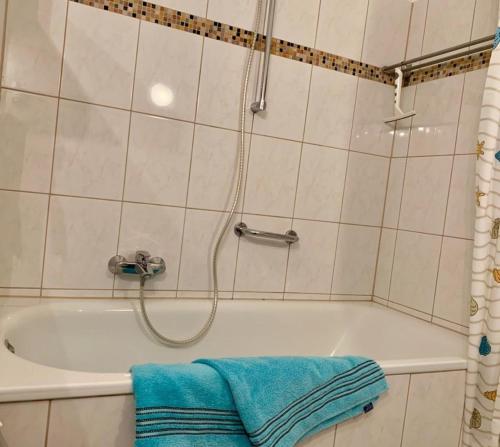 uma casa de banho com uma banheira e uma toalha azul em 13-18, sehr Strandnah, im Herzen Westerlands, Westbalkon, 1 Zi em Westerland