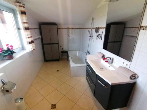 a bathroom with a sink and a toilet and a tub at Ferienwohnung Mair in Innsbruck