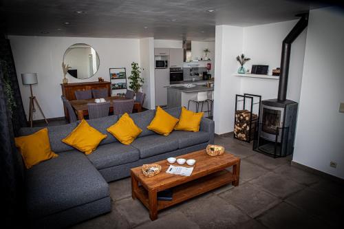 ein Wohnzimmer mit einem blauen Sofa und gelben Kissen in der Unterkunft Infiniment Vôtre in Onhaye