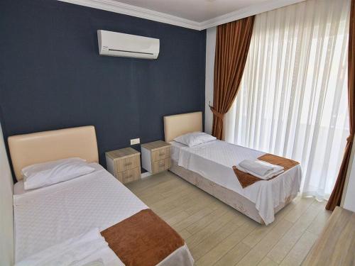 a hotel room with two beds and a window at Airport Güllük Otel in Milas