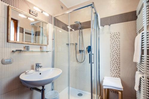 a bathroom with a sink and a glass shower at La Grotta Hotel in San Marino