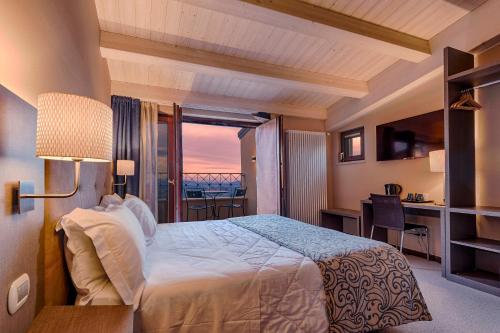 a bedroom with a bed with a view of the ocean at La Grotta Hotel in San Marino