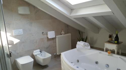 a bathroom with a white tub and a toilet at UNAHOTELS Eco Hotel Villa Costanza Venezia in Mestre