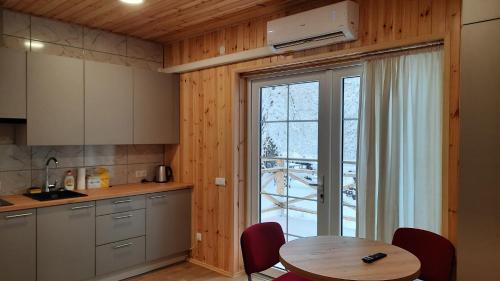 uma cozinha com uma mesa e uma grande janela em Namelis Šiaurėje em Kaltanėnai