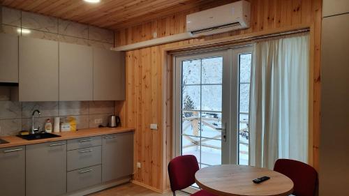 a kitchen with a table and a large window at Namelis Šiaurėje in Kaltanėnai