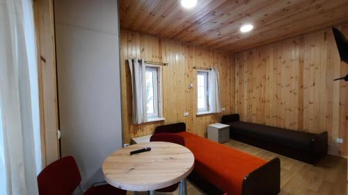 Habitación con mesa, sofá, mesa y sillas. en Namelis Šiaurėje en Kaltanėnai