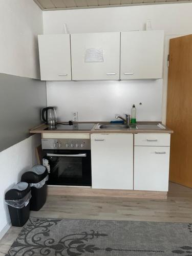 a kitchen with white cabinets and a stove top oven at Ferienwohnung Kassel Zentral in Kassel