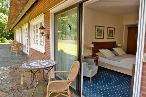 ein Schlafzimmer mit einem Bett und einem Tisch auf einer Terrasse in der Unterkunft Kleinhuis Hotel Mellingburger Schleuse in Hamburg