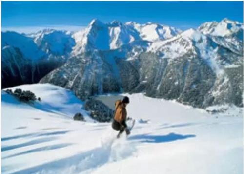 a man is skiing down a snow covered mountain at Appartement 4-6 pers proche centre village in Saint-Lary-Soulan
