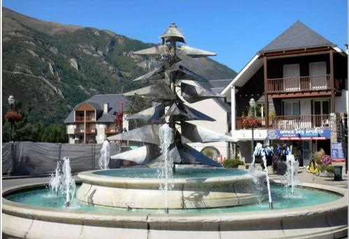 a fountain with a christmas tree in front of a building at Appartement 4-6 pers proche centre village in Saint-Lary-Soulan