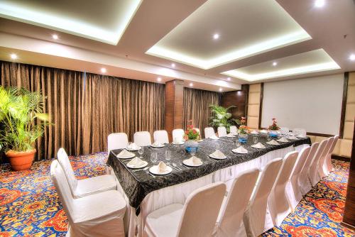 a conference room with a long table and white chairs at Best Western Summerlea in Jalandhar
