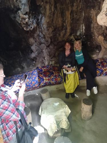 a group of people sitting in a cave at Spring Family Guest House in Tersak