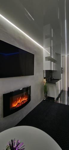 比亞韋斯托克的住宿－Chill LUX，客厅设有壁炉和墙上的电视