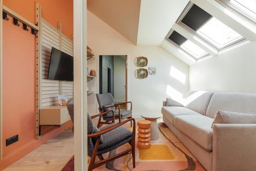 a living room with a couch and a tv at Hôtel Préfecture - Entrée autonome, réception en ligne - Encore Mieux in Limoges