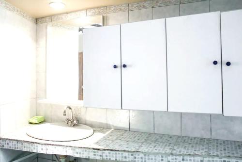 uma casa de banho com um lavatório e armários brancos em Appartement de 2 chambres avec vue sur la ville et wifi a Marseille a 4 km de la plage em Marselha