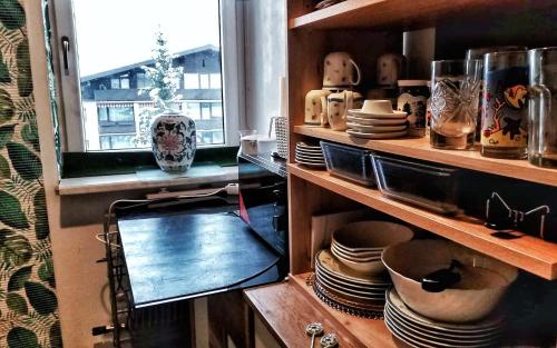 een keuken met een plank met borden en een raam bij Appartement Moni XXL 66m2 in Kaprun