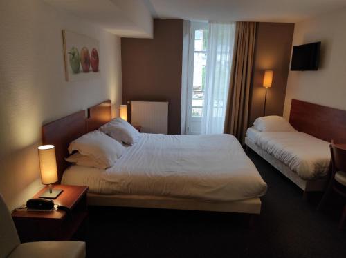 a hotel room with two beds and a window at Hôtel La Rivière in Entraygues-sur-Truyère