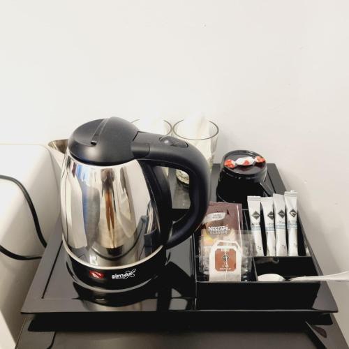 a black tea kettle sitting on top of a shelf at Hostal Lauria in Madrid