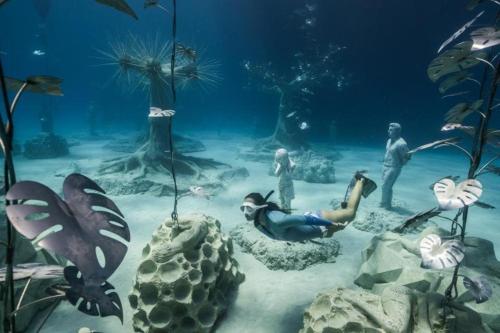 a group of people standing in the water with animals at Vrissiana Boutique Beach Hotel in Protaras
