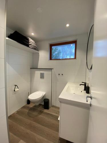 La salle de bains blanche est pourvue de toilettes et d'un lavabo. dans l'établissement Laugavellir - House, à Kleppjárnsreykir