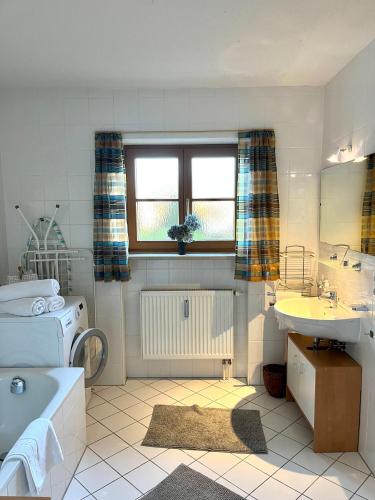 a bathroom with a tub and a sink and a toilet at FeWo Flair in Rottach-Egern