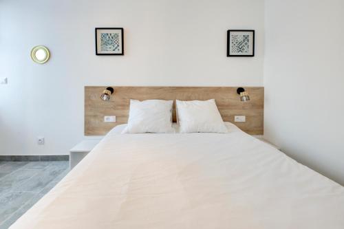 a bedroom with a large white bed with two pillows at Les forges 2 pièces RDC in Avoine