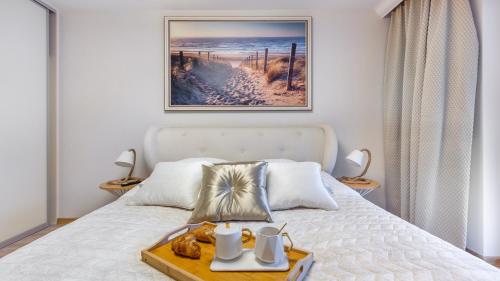 um quarto com uma cama com uma bandeja de comida em Apartament A008 Lux Tukan Polanki Park - Holiday City em Kolobrzeg