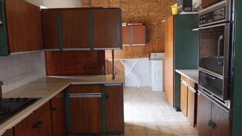 a kitchen with wooden cabinets and a stove top oven at Jay's Guest House in Witbank