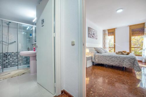 - une chambre avec un lit et une salle de bains pourvue d'une douche dans l'établissement La Perla del Centro, à Cordoue