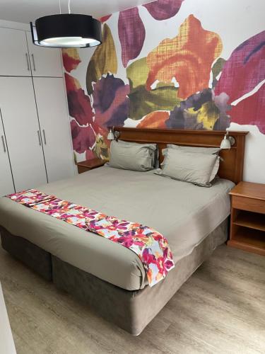 a bed in a room with a painting on the wall at Oceanic View in Durban