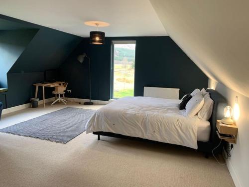 1 dormitorio con cama y pared azul en Highland Hideaway in secluded riverside location en Garve