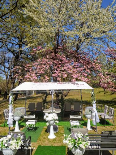 a gazebo with tables and chairs and flowers at "La Selvetta" bed and breakfast in Buguggiate