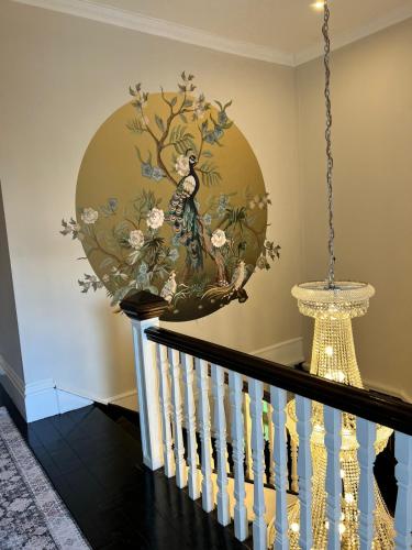 a painting of a woman on a wall next to a staircase at Smithgrove Guesthouse in Pietermaritzburg
