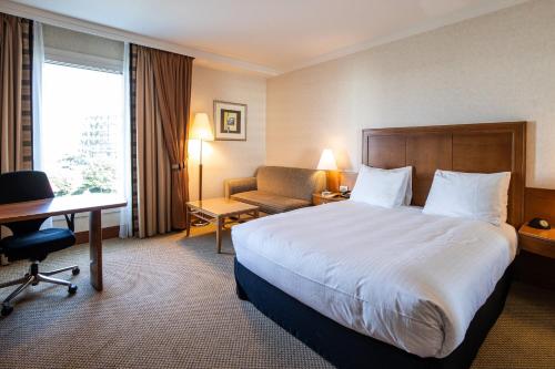 a hotel room with a bed and a desk at Crowne Plaza Brussels Airport by IHG in Zaventem