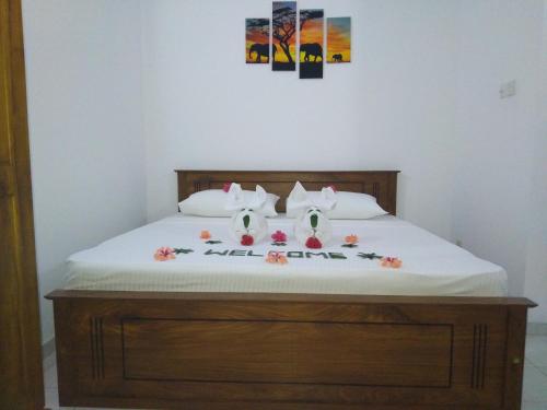 Sahani Villa في ألوثغاما: سرير مع اثنين من وسائد مرحبا كيتي عليه