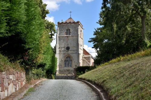 an old building with a clock tower on a road at Boat House Lodge in Shrewsbury