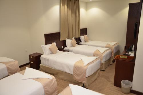 a hotel room with three beds in a room at فندق قرطبة العزيزية in Mecca