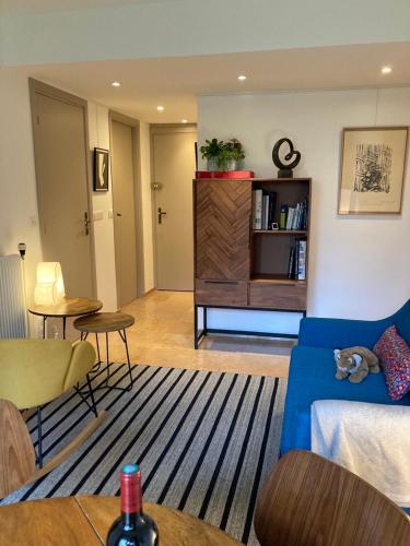 un salon avec un canapé bleu et une table dans l'établissement Vue sur jardin, 3 pièces, à Paris