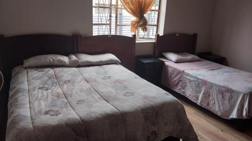 a bedroom with two beds and a window at Jay's Guest House in Witbank