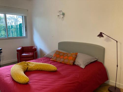 Un dormitorio con una cama con un objeto amarillo. en Vue sur jardin, 3 pièces en París
