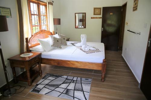 a bedroom with a bed with white sheets and a table at Tannette Villa in La Digue