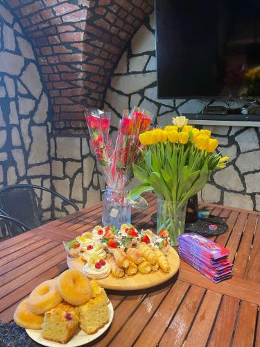 a wooden table with two plates of food and flowers at Agroturystyka Ranczo Gościszów in Nowogrodziec