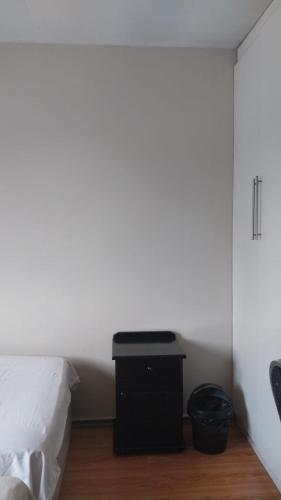 a bedroom with a bed and a white wall at Jay's Guest House in Witbank