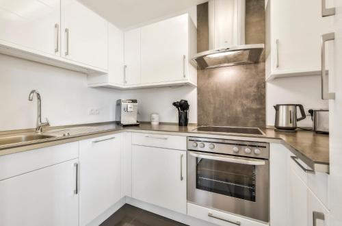 a white kitchen with white cabinets and a stove at Best Western Plus Hotel Papenburg in Papenburg