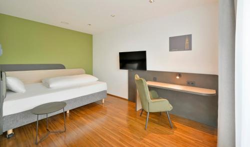 a bedroom with a bed and a desk and a chair at Best Western Plus Hotel Papenburg in Papenburg