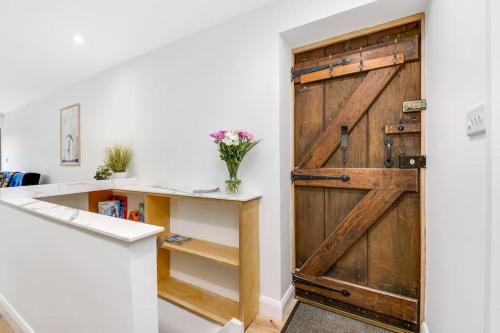 a sliding barn door in a room with a desk at The Keep at Castlegate - Luxury detached retreat in Cragg vale, Hebden Bridge in Mytholmroyd