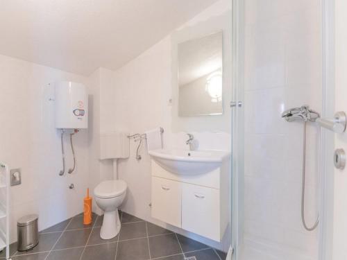 a white bathroom with a sink and a toilet at Villa Blanka in Podgora