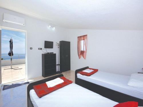 two beds in a room with a view of the ocean at Villa Blanka in Podgora