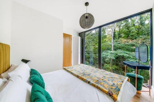 a bedroom with a bed and a large window at The Keep at Castlegate - Luxury detached retreat in Cragg vale, Hebden Bridge in Mytholmroyd