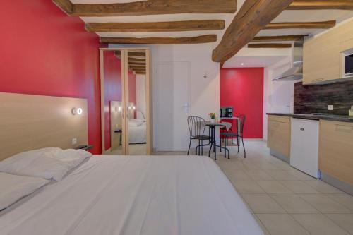 ein Schlafzimmer mit einem weißen Bett und einer roten Wand in der Unterkunft La Petite Maison appartement 1 in Avoine
